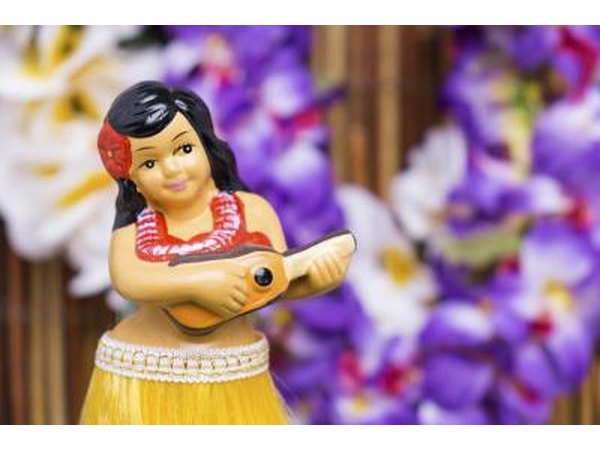 Close-up of a hula girl figurine in front of Hawaiian leis