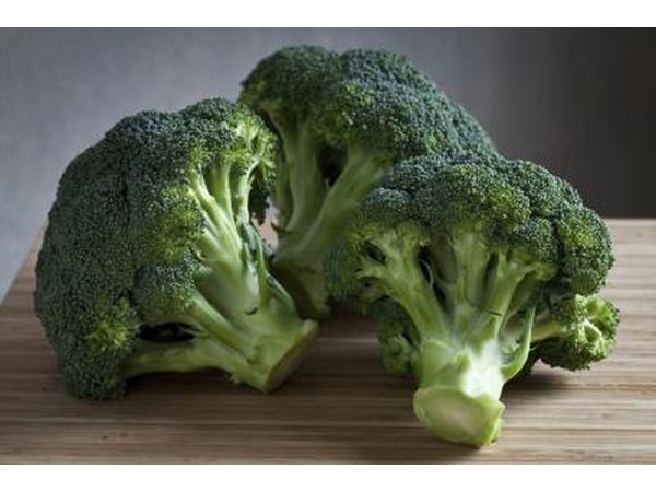 Pieces of fresh broccoli on cutting board.