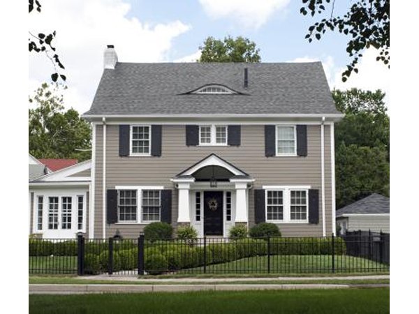 A light gray home with a dark gray door and shutters.