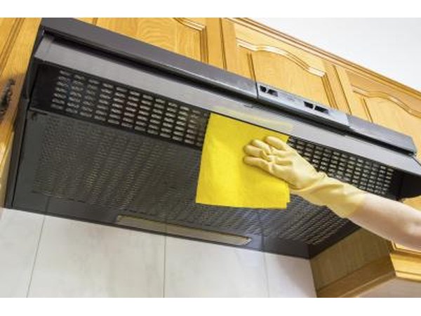 Ventilation hood for a gas stove top being cleaned.