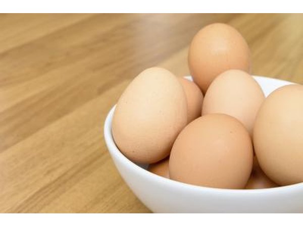 Eggs in a white bowl on a wooden table