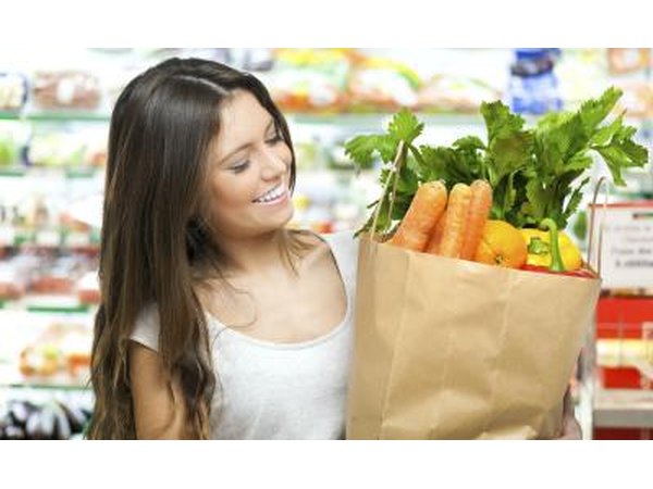 A woman is leaving the grocery store with healthy foods.