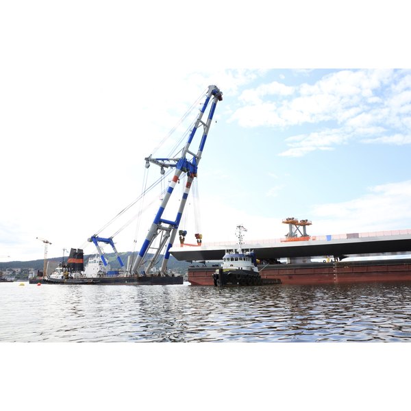 Goran/iStock/Getty Images bridge lift by crane on a barge