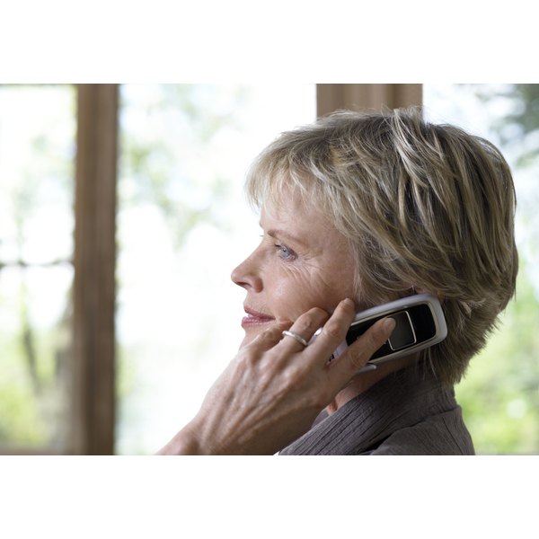 Michael Blann/Photodisc/Getty Images Mature woman using mobile phone, profile, close-up
