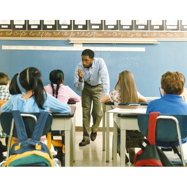 Digital Vision./Digital Vision/Getty Images Teacher Answering a Girl in a Primary School Class
