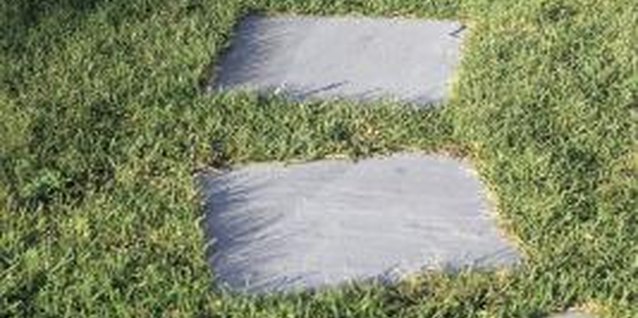 Comstock/Comstock/Getty Images Set stepping stones into the soil so you can mow right over the path.
