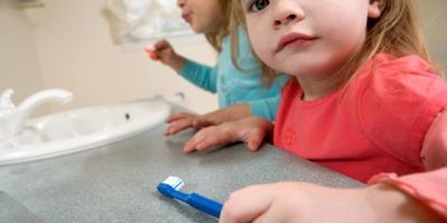 Jupiterimages/Photos.com/Getty Images Use fun activities to convince your preschooler of the importance of brushing her teeth.