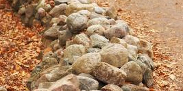 Jupiterimages/Photos.com/Getty Images Faux stone edging is lighter weight than their natural stone counterparts.