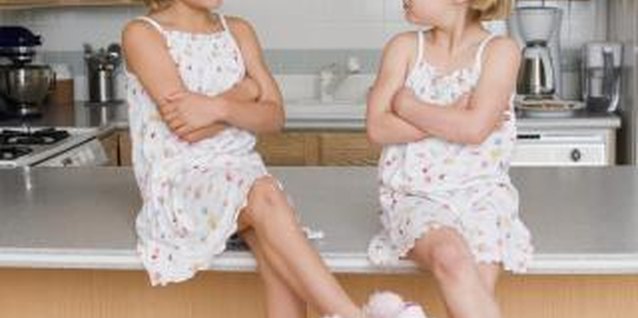 Jupiterimages/Creatas/Getty Images Your girls might compete for your attention or to see who is better at certain activities.