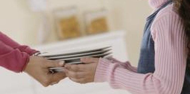 Comstock Images/Comstock/Getty Images Let your child help you set the table.