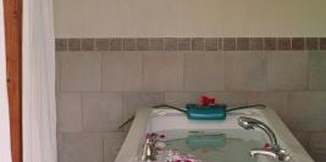 Jupiterimages/Photos.com/Getty Images Accent tiles can create a striking border for the walls in your tub area.