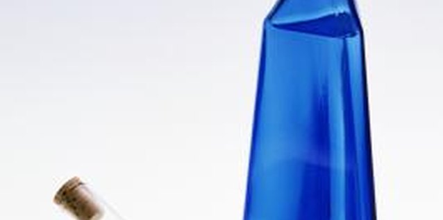 Thinkstock Images/Comstock/Getty Images Save blue bottles of all shapes and sizes for your walkway border.