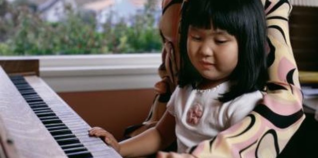 Creatas/Creatas/Getty Images Nurture your little one's creative expression at the piano.