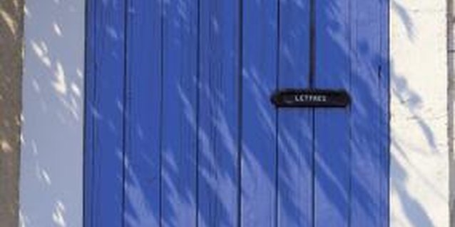 Stockbyte/Stockbyte/Getty Images Bright blue shutters provide a strong colored background for painted flowers.