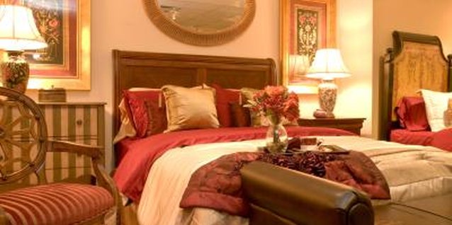 Jupiterimages/Photos.com/Getty Images Drape a luxurious throw across the corner of your bed to create the feel of a five-star hotel.