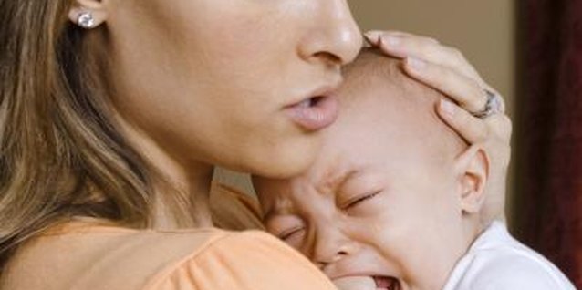 Jupiterimages/Creatas/Getty Images Chewing and fussiness are signs of teething.