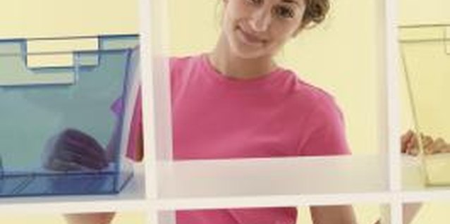 Comstock/Comstock/Getty Images Using containers to hold smaller items can help keep your wall unit's shelves neat and organized.