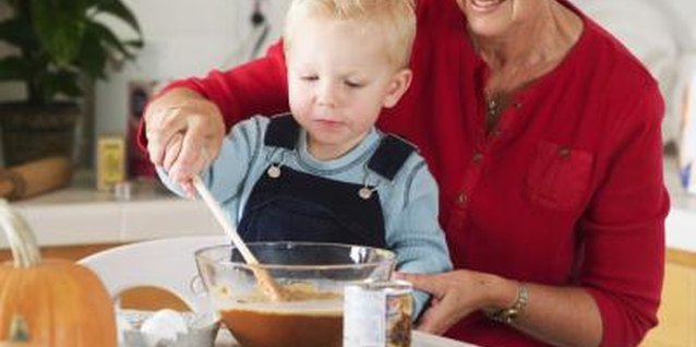 Jupiterimages/Brand X Pictures/Getty Images Cooking together offers warm, home-centered lessons on your family's customs.