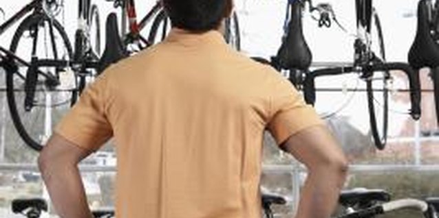 Thomas Northcut/Photodisc/Getty Images Bike shops display and store bikes by hanging them from the wheels.