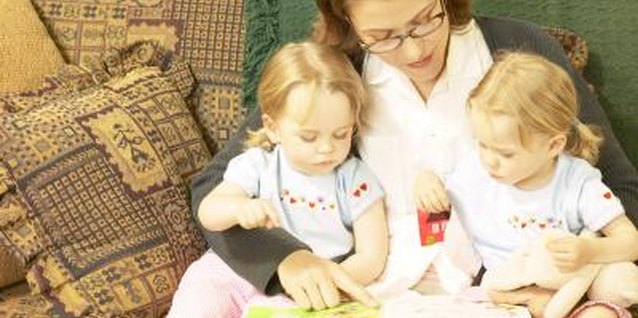 Hemera Technologies/AbleStock.com/Getty Images Reading with your children helps them develop language skills.