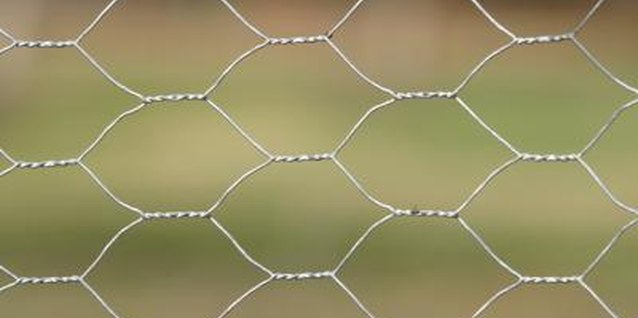 Jupiterimages/Photos.com/Getty Images Chicken wire is a woven fencing material that is resistant to rust.
