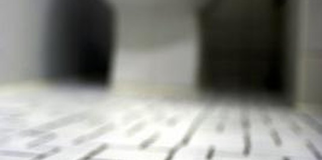 Thinkstock/Comstock/Getty Images Installing a toilet flange on tile requires some pre-drilling.