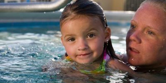 Jupiterimages/Photos.com/Getty Images Keep within an arm's length of your preschooler as she learns to swim.