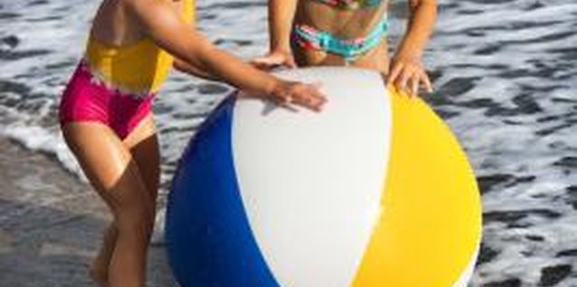 Jupiterimages/Comstock/Getty Images Your kids enjoy playing with a sphere at the beach.
