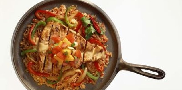 Jupiterimages/Comstock/Getty Images Bake a frozen halibut filet and vegetables in a cast-iron skillet.