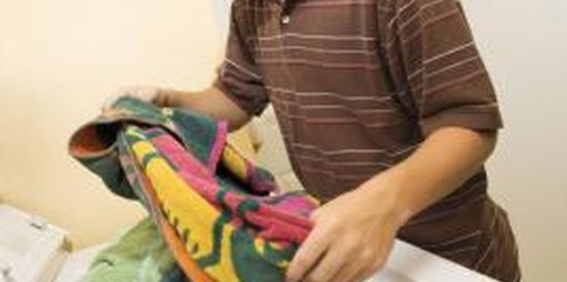 Jupiterimages/Comstock/Getty Images Tell your teen, white towels get hot water, but bright colored towels get warm or cold water, to keep them from fading.