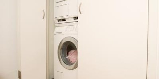 Jupiterimages/Photos.com/Getty Images A stacking washer-and-dryer unit is easy to hide behind a door.