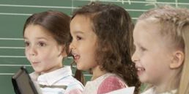 Digital Vision./Digital Vision/Getty Images Learning to sing and play a musical instrument can boost your child's mental prowess.
