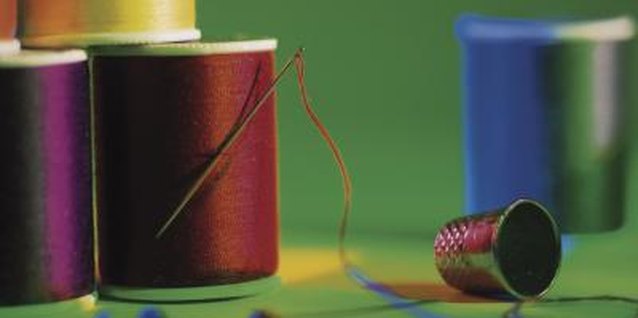 Comstock Images/Comstock/Getty Images Needle and thread are all you need to stitch simple tabs to the top of a quilt.