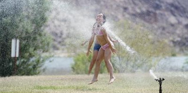 Polka Dot Images/Polka Dot/Getty Images Sprinklers can waste water, but sometimes it's worth it.