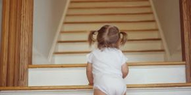Ryan McVay/Photodisc/Getty Images Keep toddlers from climbing stairs by giving them safe things to practice climbing on.