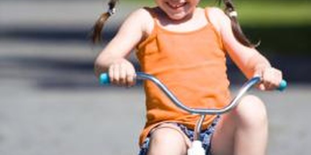 Jupiterimages/Photos.com/Getty Images Riding her tricycle is a fun way for your preschooler to get exercise.