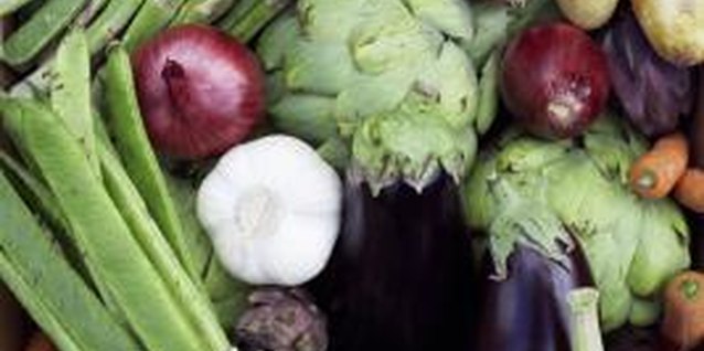 Martin Poole/Photodisc/Getty Images Asparagus grows perennially; garlic grows annually.