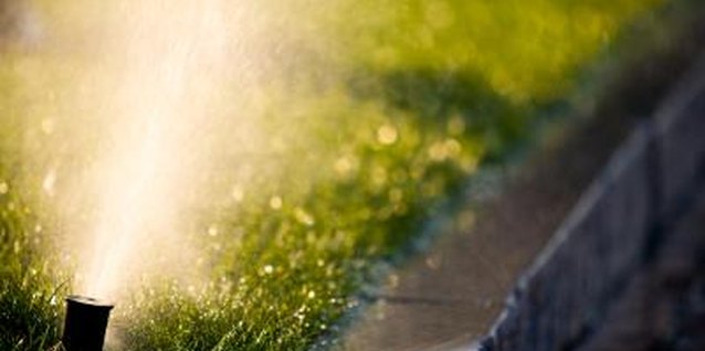 Jupiterimages/Photos.com/Getty Images Fine tune a pop up sprinkler head for the best water dispersion.