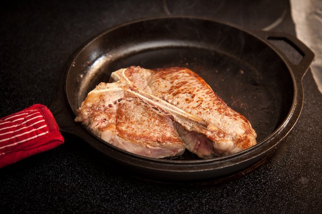 Steak cooking in a cast-iron skillet.