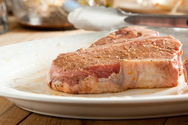 Raw T-Bone steak on plate.