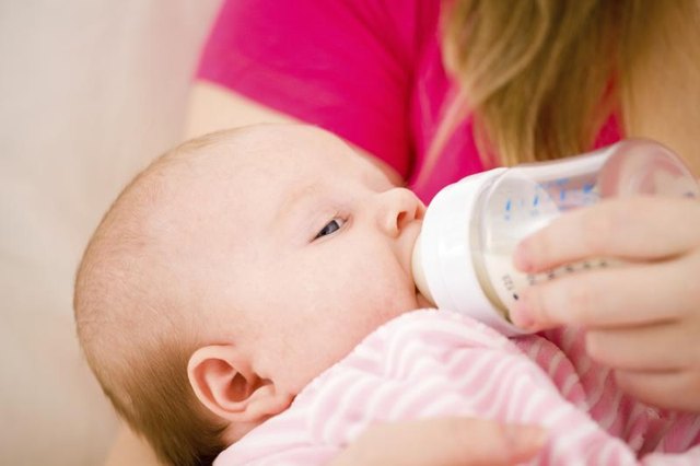 Close-up of newborn being bottle-fed.