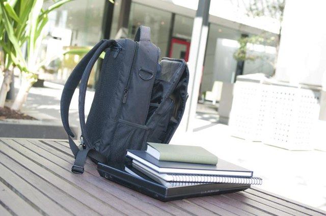 A backpack and school books on a table.