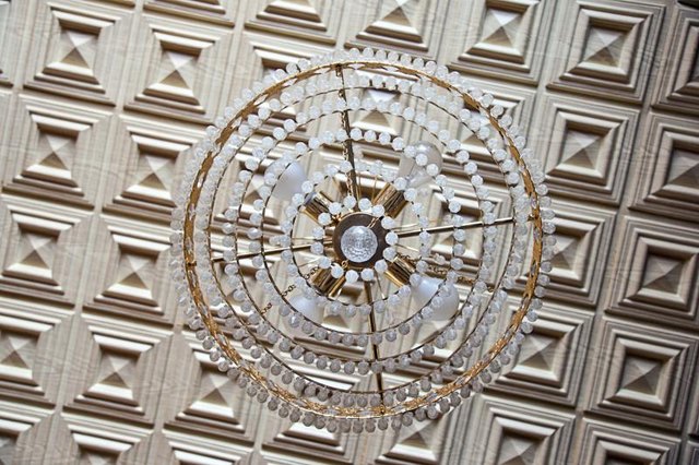 Tin tiles behind a chandelier.