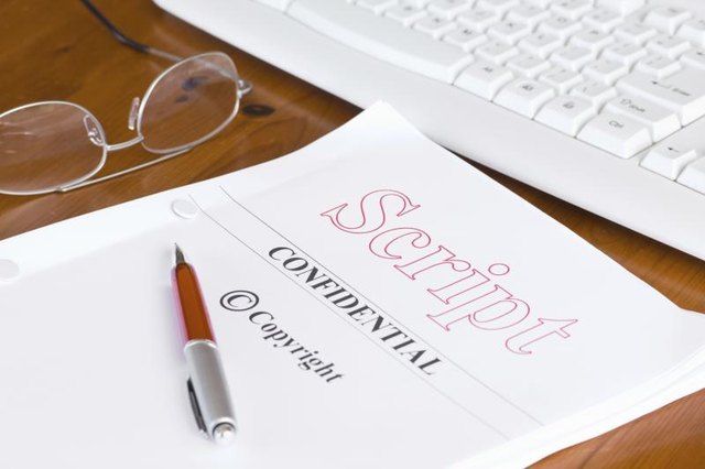 A script with a pen, glasses and a computer keyboard.