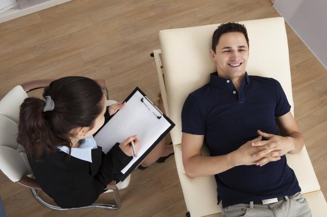 A high-angle view of a patient communicating with his therapist.