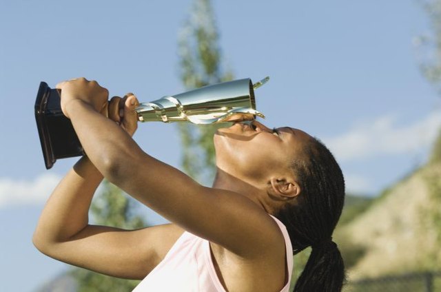 Female athlete kissing a trophy.