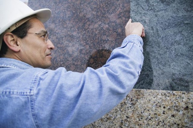 Man examining sheets of granite.