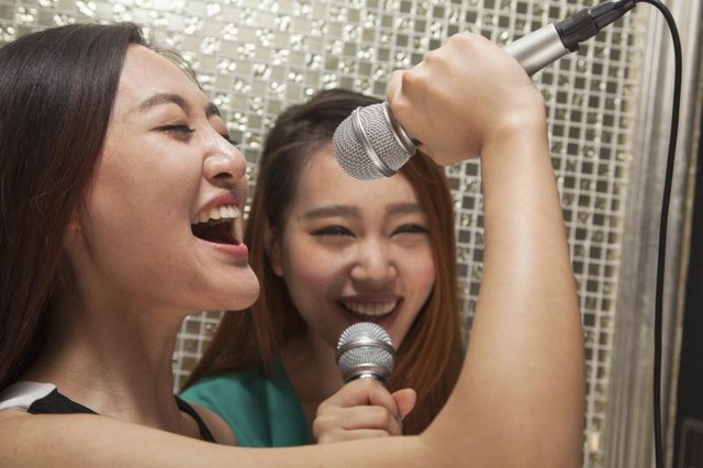Women singing into microphones