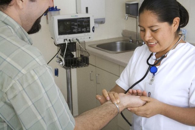 A nurse checking the pulse of a patient in a medical office.
