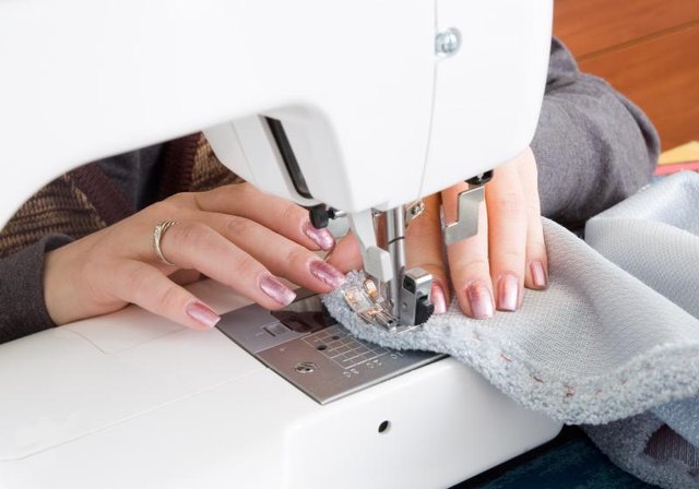 Hands using a sewing machine.